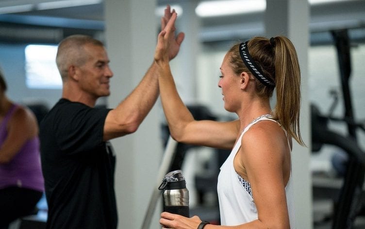 A personal trainer high-fiving a client.