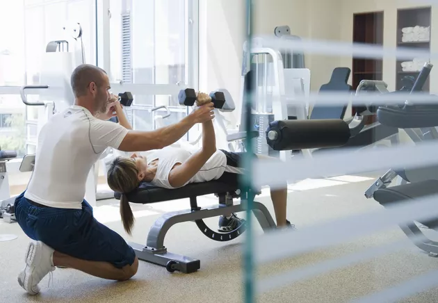 A personal trainer stretching out a client.